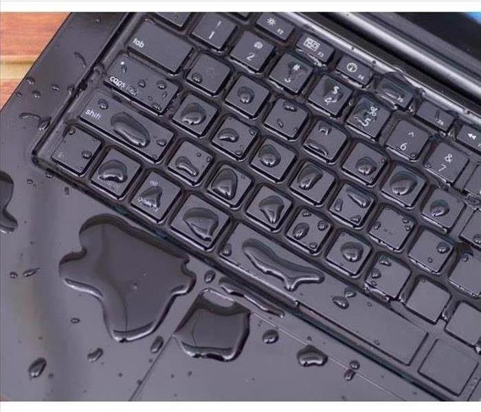 a black keyboard with water on it 